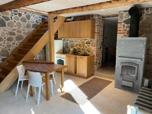 a kitchen with a table and a wood stove at Lättemaa in Raanitsa