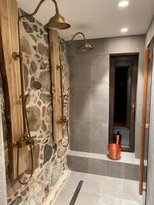 a bathroom with a shower with a stone wall at Lättemaa in Raanitsa