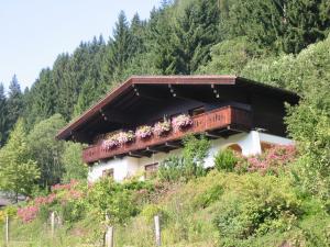 een huis met een balkon met bloemen erop bij Ferienwohnung Hans Ebner in Eben im Pongau