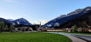 ein kleines Dorf in den Bergen mit einer Kirche in der Unterkunft Gasthof-Fleischerei Engl in Kötschach