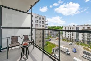 a balcony with two chairs and a view of a street at Apartament Baltic Bay Grudziądzka 4B Gdansk TriApart in Gdańsk
