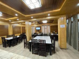 una sala da pranzo con tavoli, sedie e lucernario di HOTEL KHARDONGLA a Leh