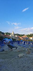 a beach with lots of blue chairs and buildings at L’angolo d’aMare in Lerici