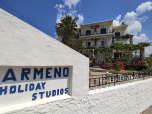 a sign in front of a building with aania holiday studios at Armeno Studios in Limenaria