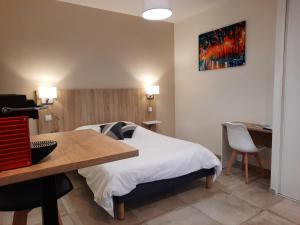 um quarto de hotel com uma cama, uma secretária e um quadro em Le Logis de Bérianne em Les Tourrettes