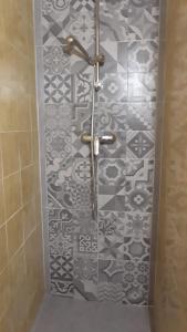 a shower in a bathroom with black and white tile at TERRA SICULA - vacanze modicane in Modica