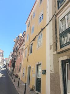 ein gelbes Gebäude an der Straßenseite in der Unterkunft Principe Real Central Home in Lissabon