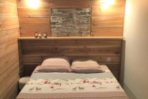 1 dormitorio con 1 cama con cabecero de madera en Grand T2 4 voyageurs tout confort en Cauterets