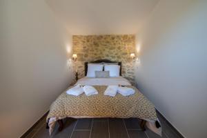 1 dormitorio con 1 cama con toallas en LA MAISON DE LIVIA, chambres et table d'hôtes, en Sauzet