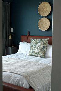 a bedroom with a bed with a blue wall at Rose Gold @The Winchester in Cape Town