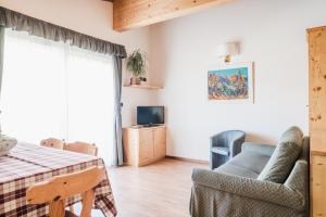 sala de estar con mesa y silla en Residence Dolomia, en Pozza di Fassa