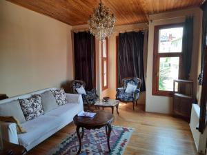 a living room with a couch and chairs and a chandelier at Manzaraada Merkez in Heybeliada