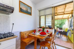 uma cozinha e sala de jantar com uma mesa de madeira e cadeiras em Apartments Vivijana em Rabac