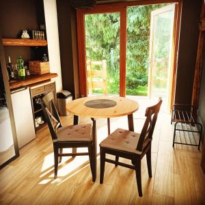a table and chairs in a kitchen with a window at GÓRNA VIBES in Jugowice