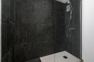 a bathroom with a shower with black tiles at iloftmalaga Ricardo Soriano in Marbella +35 photos