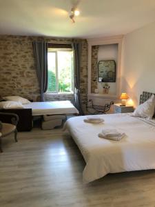 um quarto de hotel com duas camas e uma janela em Les Tilleuls em La Porcherie