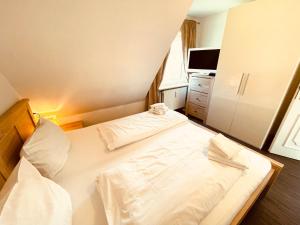 une chambre avec un grand lit avec des draps et des oreillers blancs dans l'établissement Appartement yoursylt.two, à Westerland