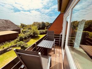 einen Balkon mit einer Bank und einem Tisch darauf in der Unterkunft Appartement yoursylt.two in Westerland