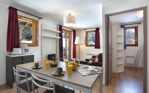 cocina y sala de estar con mesa y sillas en Vacancéole - Au Coeur des Ours, en Les Deux Alpes