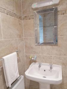 a bathroom with a sink and a mirror at Inspiration Lodge in Anascaul