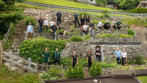 eine Gruppe von Menschen, die auf den Stufen eines Gartens stehen in der Unterkunft Kräuterhotel Hochzillertal 3 Sterne Superior in Kaltenbach
