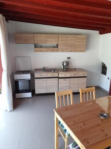a kitchen with a wooden table and a stove top oven at Casa Zoe Seaca in Călimăneşti