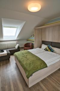 a bedroom with a large bed and a couch at Apartmenthaus Hohenfels in Helgoland