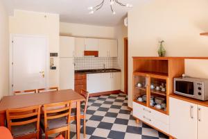 cocina con mesa y microondas en Milan Residence, en Rosolina Mare