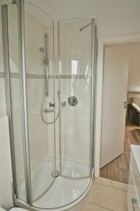 a shower with a glass door in a bathroom at Apartmenthaus Hohenfels in Helgoland