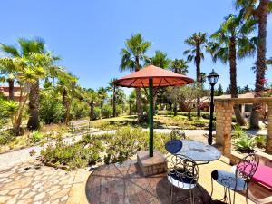 a patio with a table and chairs and an umbrella at Quinta do Mar - Country & Sea Village in Luz