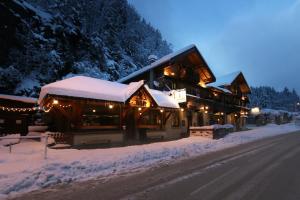 a building covered in snow with lights on it at Vert Lodge Chamonix in Chamonix-Mont-Blanc