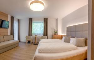 um quarto com 2 camas e um sofá em Garni Hotel Am Meilenstein em Rabla