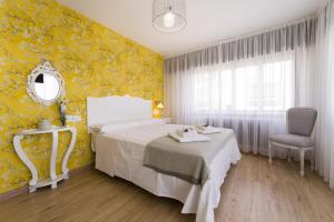 1 dormitorio con cama blanca y pared amarilla en PENSIÓN FERRADURA, en Melide