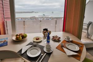 a table with plates of food and a view of the ocean at Apartmenthaus Hohenfels in Helgoland