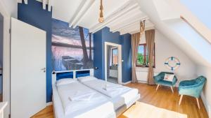 a bedroom with a white bed and blue walls at Domy nad Jeziorem Sun & Snow Osada Zamkowa in Pasym