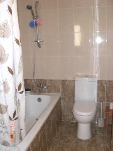 a bathroom with a toilet and a tub and a shower at St. Lazaros Seaside Apartment in Larnaka