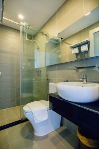 胡志明市的住宿－Lá Hotel Q10，浴室配有卫生间、盥洗盆和淋浴。