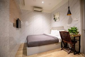 胡志明市的住宿－Lá Hotel Q10，一间小卧室,配有一张床和一张书桌