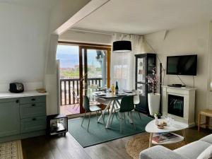 een keuken en een woonkamer met een tafel en een balkon bij Le Van Gogh - YourHostHelper in Deauville