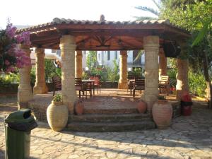 un pabellón con una mesa y sillas en un patio en Assimakis Hotel, en Finikounta