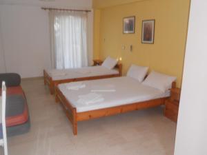 a bedroom with two beds and a window at Assimakis Hotel in Finikounta