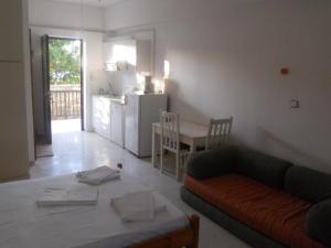 a living room with a couch and a table and a kitchen at Assimakis Hotel in Finikounta
