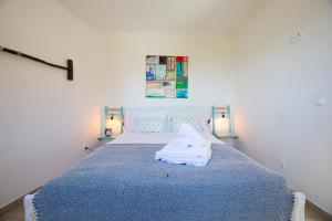 1 dormitorio con 1 cama con manta azul en Casa Passarinho, en Aljezur