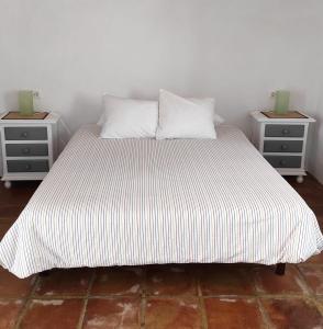 a large bed with two nightstands and twoials at Casa Cabra in Montejaque