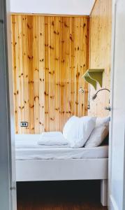 a bed in a room with a wooden wall at Oseli22 in Lavarone