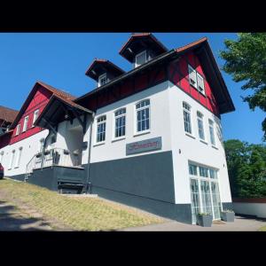 een groot wit gebouw met een rood dak bij Haus Hennesburg, garni in Eisenach