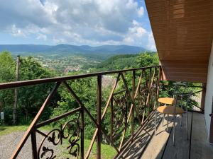 a balcony with two chairs and a view of the mountains at Садиба Краєвид in Polyana