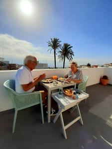 two people sitting at a table eating food on a balcony at Villa Nestor in Ingenio
