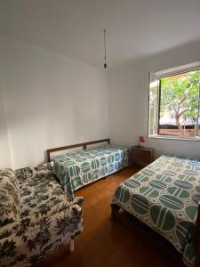 sypialnia z dwoma łóżkami i oknem w obiekcie Appartamento mare e relax w mieście Gioiosa Marea