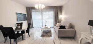 a white living room with a couch and a table at Leo Royal Apartament Pobierowo in Pobierowo